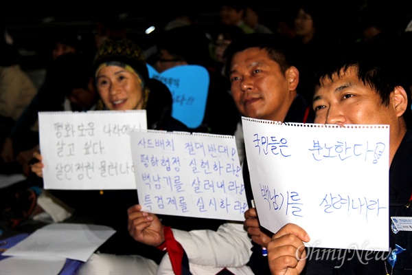 21일 저녁 창원 정우상가 앞에서 열린 '창원 민중대회'에 참가자들이 구호를 적어서 들어보이고 있다.