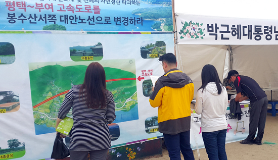  ‘의좋은형제축제’를 찾은 방문객들이 서부내륙고속도로 대흥통과노선을 본 뒤 대통령에게 보내는 편지를 쓰고 있다.