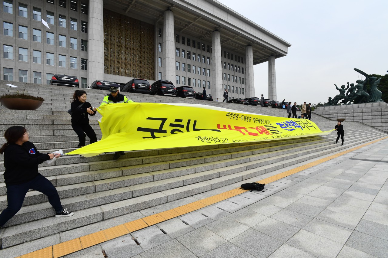 대학생 4여명이 26일 오후 국회본청 계단앞에서 기습 시위를 벌이며 "박근혜 대통령 탄핵"을 외치며 현수막을 펼치고 있다.