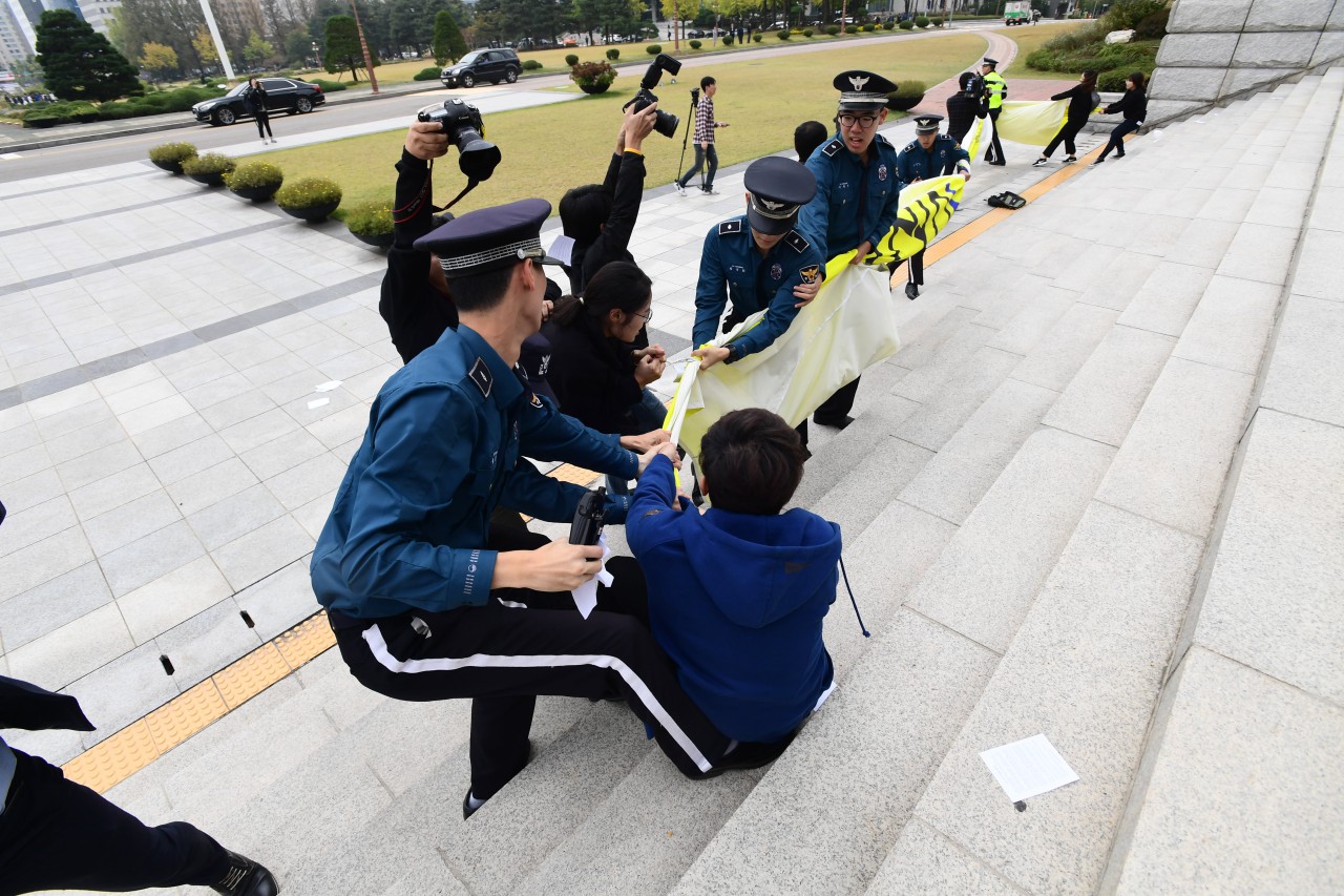 대학생 4여명이 26일 오후 국회본청 계단앞에서 기습 시위를 벌이며 "박근혜 대통령 탄핵"을 외치고 있다.