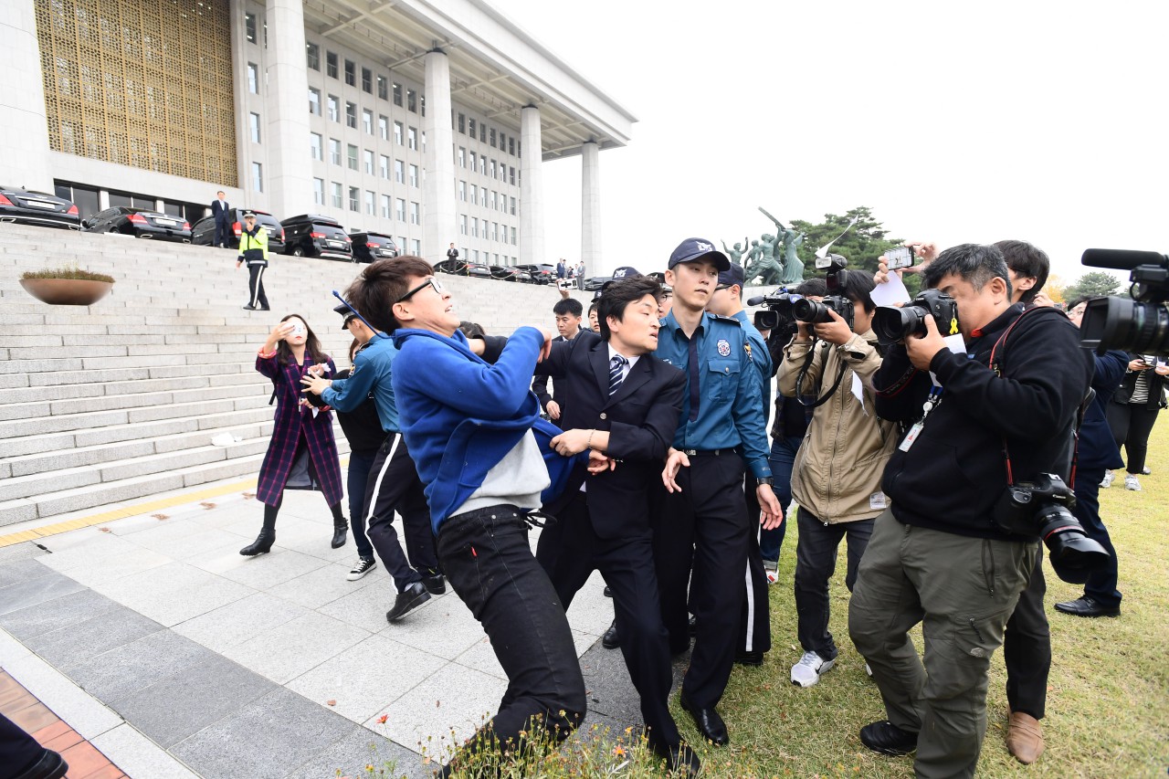 대학생 4여명이 26일 오후 국회본청 계단앞에서 기습 시위를 벌이며 "박근혜 대통령 탄핵"을 외치다 국회 방호원에 의해 저지 당하고 있다.