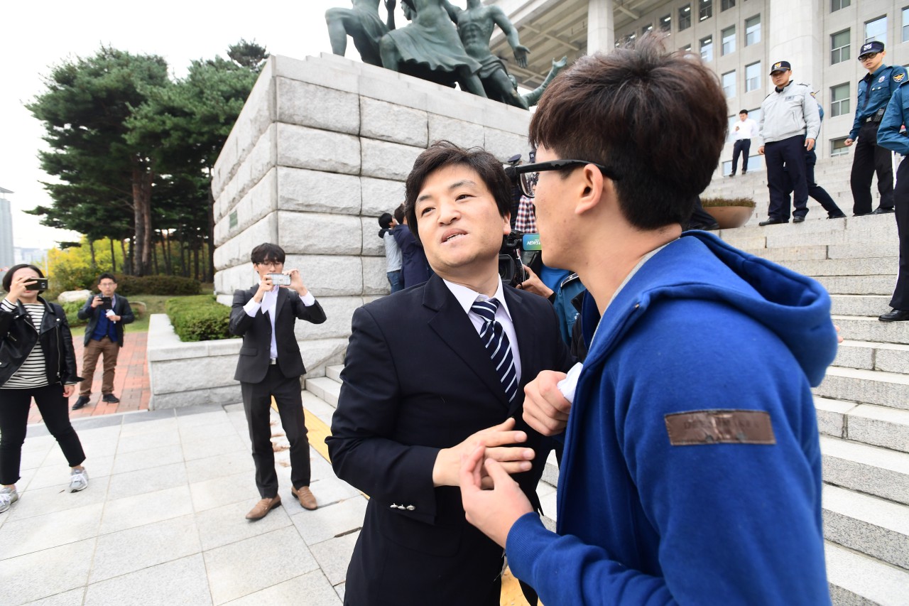 대학생 4여명이 26일 오후 국회본청 계단앞에서 기습 시위를 벌이며 "박근혜 대통령 탄핵"을 외치다 국회 방호원에 의해 저지 당하고 있다.