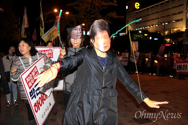 시민과 학생들이 28일 저녁 창원 한서병원 앞 광장에서 '박근혜 대통령 하야'를 촉구하는 선전전을 벌이면서 박근혜 대통령과 최순실씨의 인형을 쓰고 '꼭두각시를 선보이고 있다.