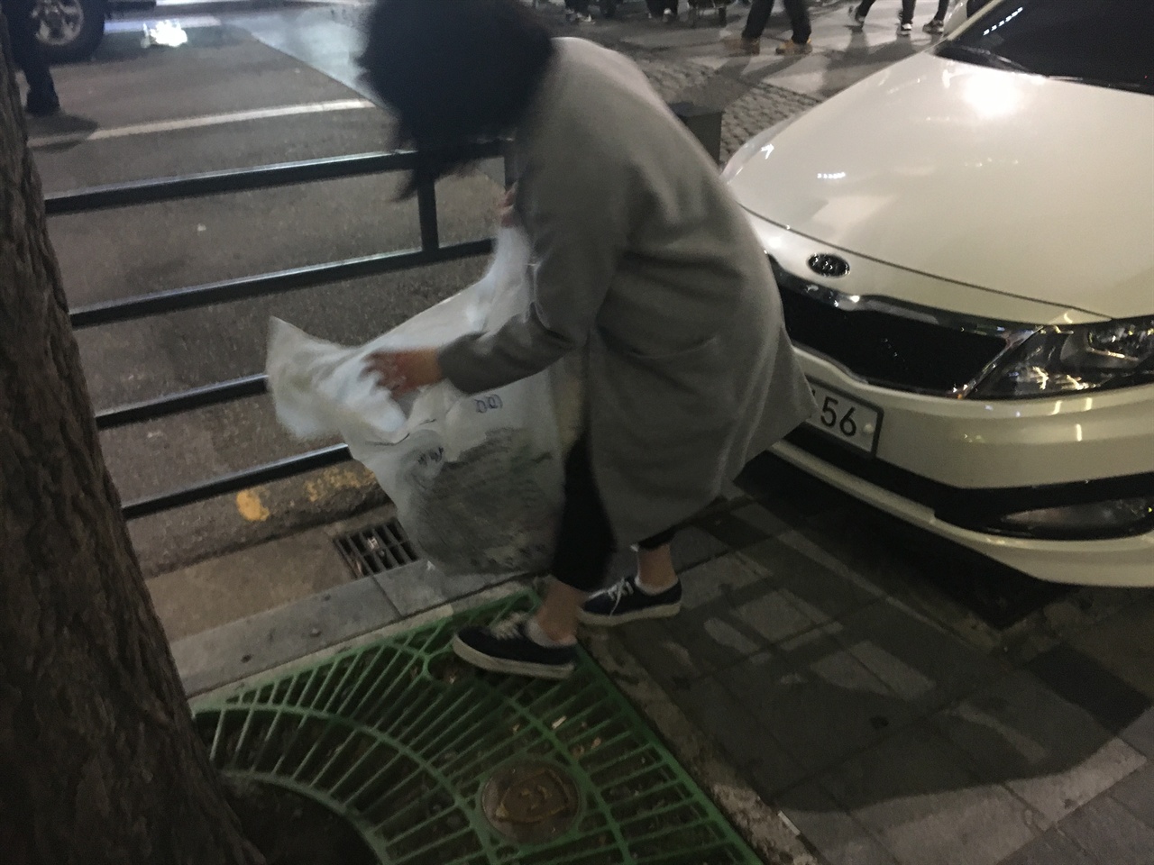 시위 행령이 지나간 자리에 나온 쓰레기들을 자진해서 쓰레기를 봉투를 들고 줍고 있다