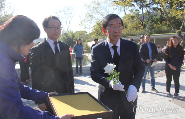 박원순 서울시장이 30일 오후 고 노무현 전 대통령 묘역을 참배하기에 앞서 국화꽃을 받아들고 있다.