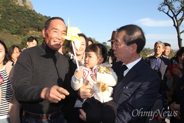 박원순 서울시장이 30일 오후 고 노무현 전 대통령 묘역을 참배한 뒤 한 아이를 안아보고 있다.
