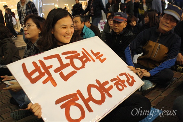 지난 28일 대구시 중구 동성로에서 열린 박근혜 대통령 하야 촛불집회에서 한 참가자가 피켓을 들고 앉아 있다.
