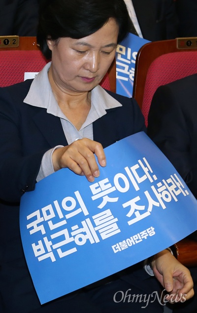 추미애 "박근혜를 조사하라" 더불어민주당 추미애 대표가 1일 오후 국회 의원회관에서 열린 '박근혜-최순실게이트' 진상규명 보고대회에서 박근혜 대통령 검찰조사를 촉구하는 피켓을 들고 있다.