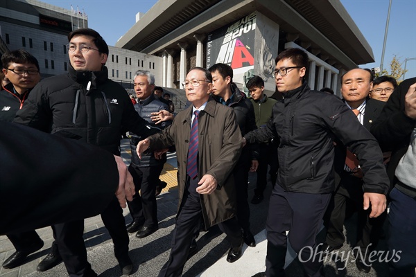 짧은 답변 마치고 승용차로 향하는 김기춘 기자들에게 쏟아지는 질문에 짧은 답변을 한 김기춘 전 대통령 비서실장이 경찰과 행사 관계자들에 둘러싸여 승용차로 향하고 있다.