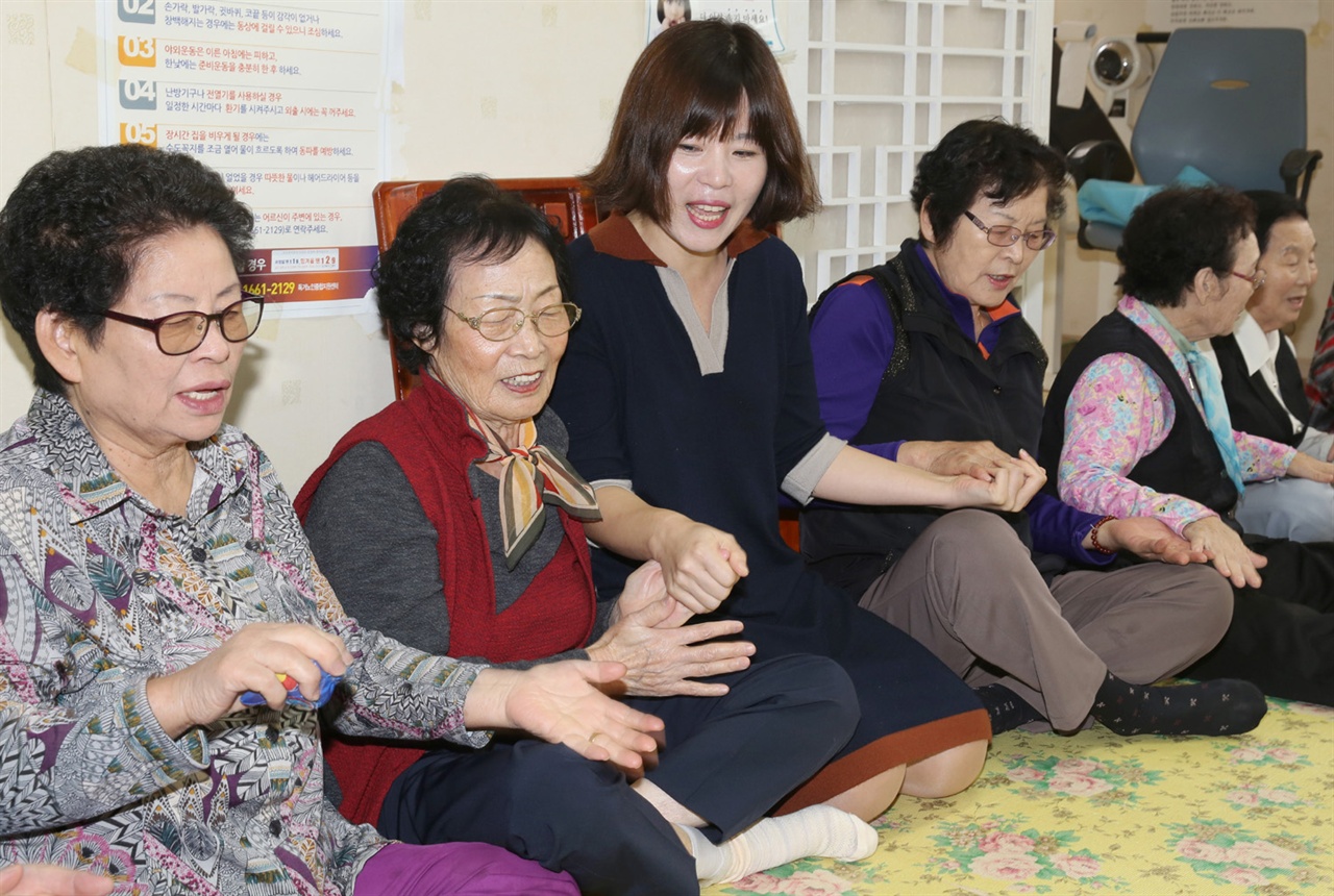  어르신들의 치매 예방 프로그램을 운영하고 있는 송은주(가운데) 한국치매예방협회 목포무안지부장이 어르신들과 함께 노래를 부르고 있다. 지난 10월 27일 전남 무안의 회룡경로당에서다.