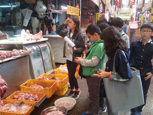 시장에서 실습 재료인 돼지를 직접 구매하는 아이들