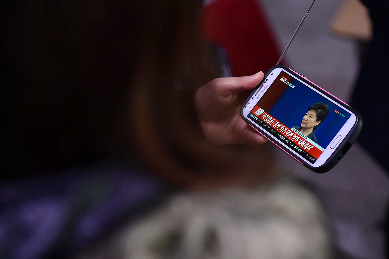 4일 오전 서울역 대합실에서 열차를 기다리던 한 시민이 스마트폰으로 박근혜 대통령의 '대국민 담화' 모습을 지켜보고 있다.