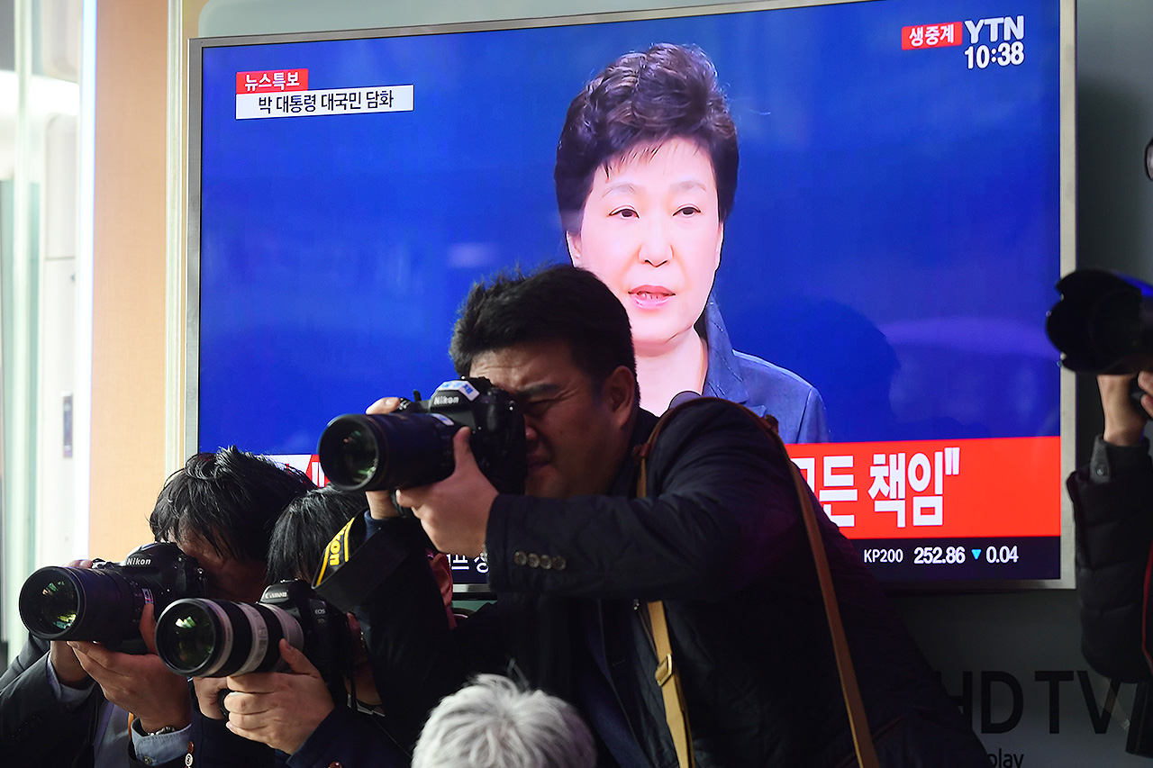 언론사 사진기자들이 4일 오전 서울역 대합실에서 TV를 통해 박근혜 대통령의 '대국민 담화' 모습을 지켜보는 시민들의 모습을 취재하고 있다.