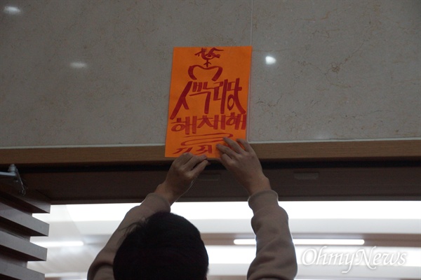 경북대 한 학생이 4일 오후 글로벌프라자 경하홀 입구에 '새누리당 해체해'라고 쓴 부적을 붙이고 있다. 