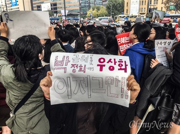  5일 고 백남기 농민 영결식이 진행 중 오후 2시께 광화문 동화면세점 앞에서 중·고등학교 학생 100여 명이 집회를 열고 있다. 집회에 참석한 한 학생이 '박근혜 대통령, 박정희 대통령 우상화 이제 그만'이라고 적힌 팻말을 들어 보이고 있다. 
