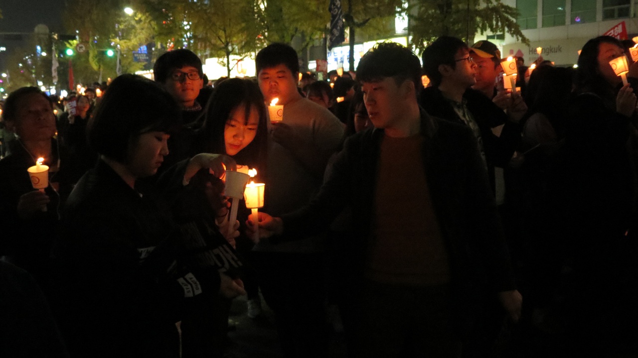 촛불을 받아들고 행진에 참여하려는 학생들.