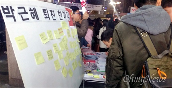 박근혜 대통령 퇴진 촉구 서명판에 서명을 하기 위해 줄을 서있는 시민들