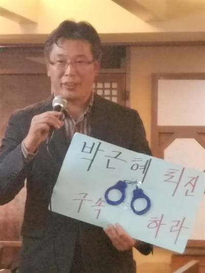 2년 전 세월호 집회 당시 사용했던 수갑을 들고 나와 "지금이야말로 박근혜 대통령을 구속해야할 때"라고 주장하는 조진만 씨.