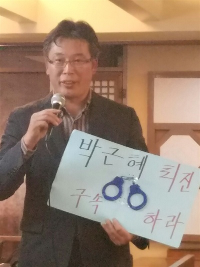  2년 전 세월호 집회 당시 사용했던 수갑을 들고 나와 "지금이야말로 박근혜 대통령을 구속해야할 때"라고 주장하는 조진만 씨.