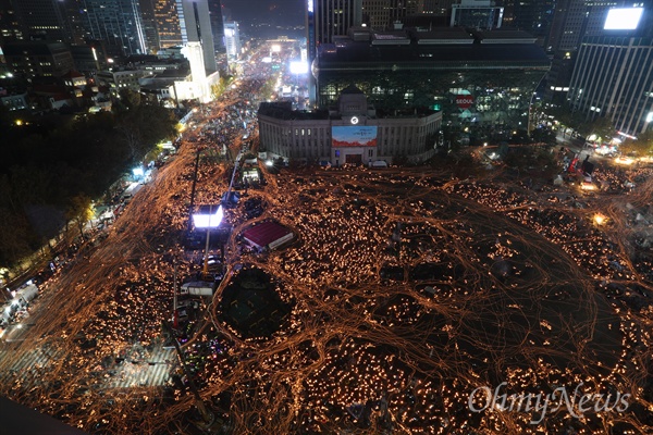 지난 12일 오후 서울시청 앞 서울광장에서 열린 2016 민중총궐기 대회에 참여한 시민들이 박근혜 대통령의 퇴진을 촉구하는 촛불을 들고 광화문, 청와대 방향으로 거리 행진을 하고 있다. 