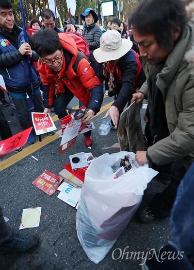 12일 오후 서울시청광장에서 열린 민중총궐기 대회가 끝난 뒤 참가자들이 쓰레기를 치우고 있다.