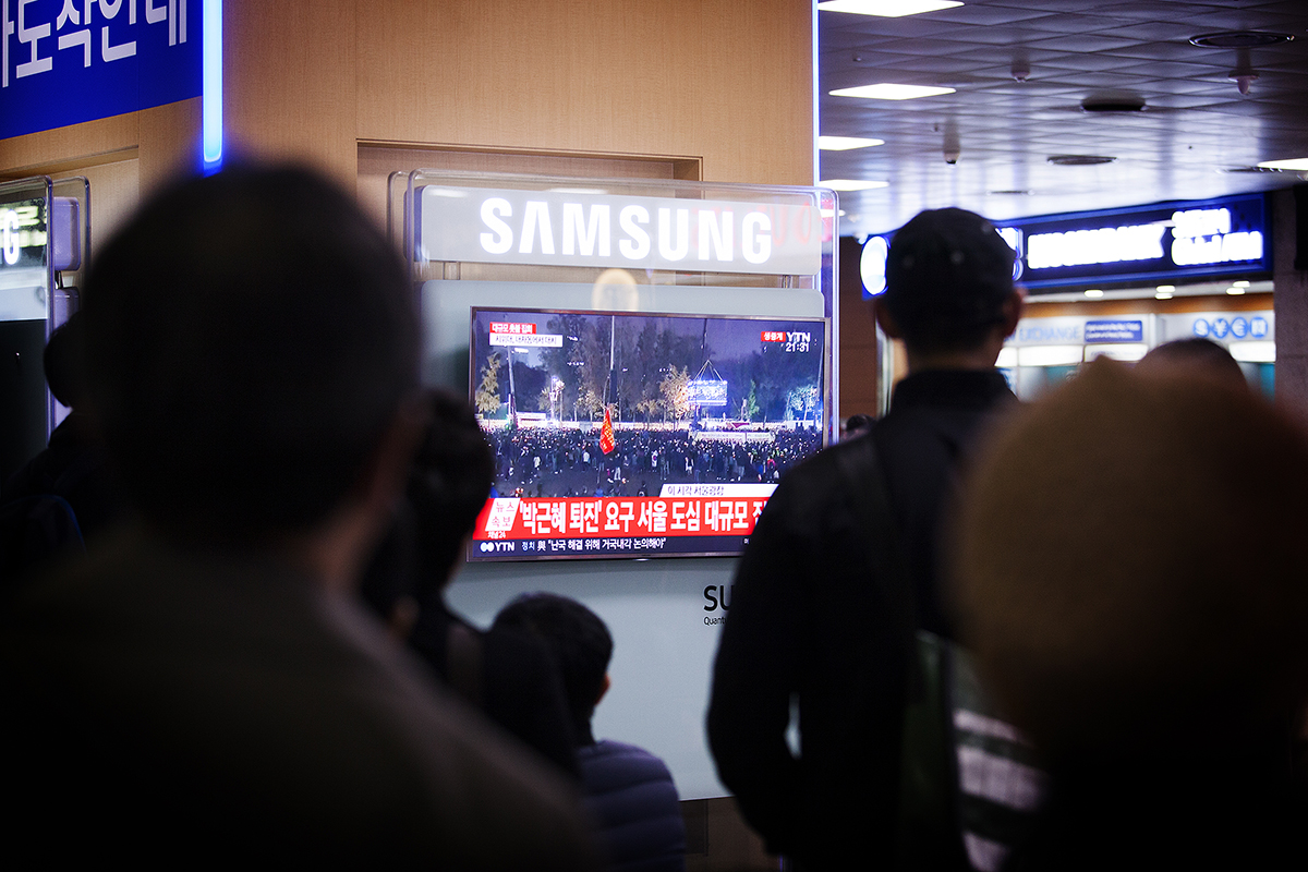 모두의 관심은 광화문으로 서울역에 모여든 시민들이 TV를 통해 광화문 집회 현장 실황을 시청하고 있다. 한편, 같은 시각 서울역 광장에서는 대통령 하야를 반대하는 집회가 약 300명 규모로 진행중이었으나 대중과 언론의 관심은 거의 없었다.