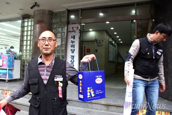 김우상 전국화학섬유산업노동조합 부산경남지부장이 14일 오후 새누리당 경남도당 앞에서 '박근혜 퇴진, 새누리당 해체 시국선언'한 뒤, 지나는 시민한테서 받은 박카스 상자를 들어보이고 있다.