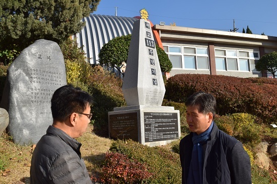 정성조 교장(오른쪽)과 이현덕 동문회 고문이 안산초교 운동장 한켠에 세워진 개교 113주년 기념탑 앞에서 이야기를 나누고 있다. 