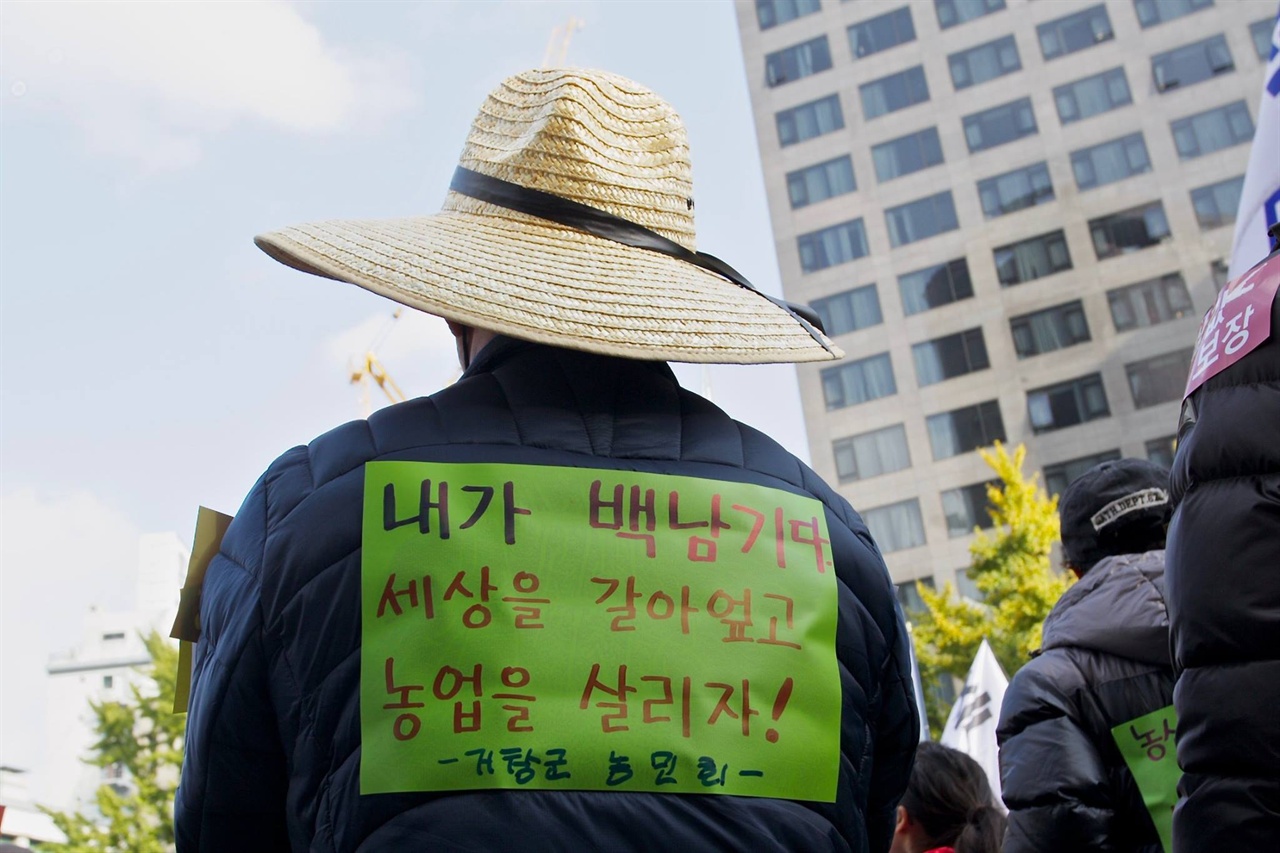 광화문 집회에 참가한 한 농민이 '내가 백남기다' 종이를 등에 붙이고 있다