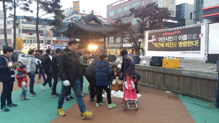  아산 시민들이 촛불을 받으려고 줄을 서고 있다. 