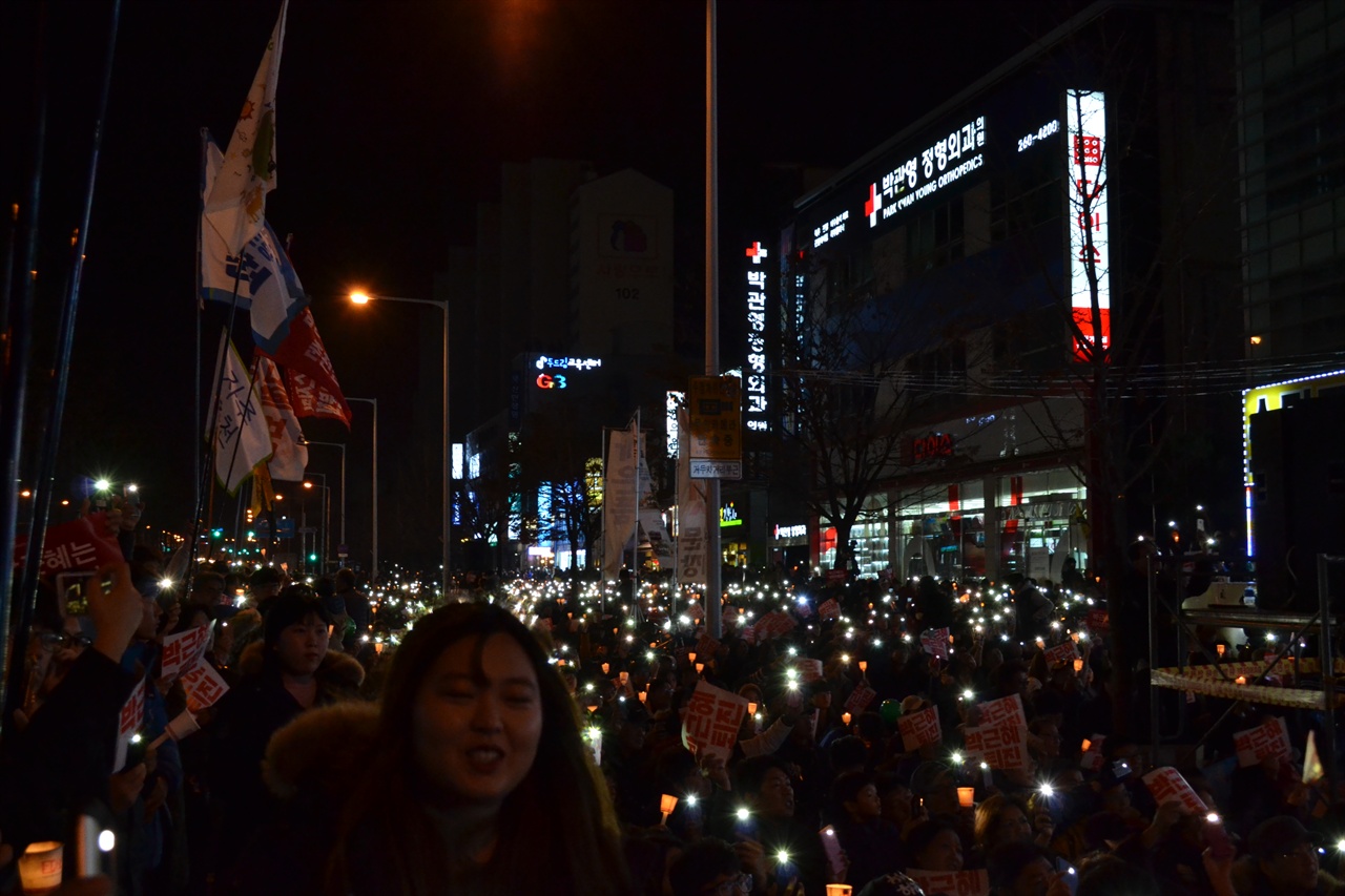 시민들이 촛불과 플래시라이트를 들고 집회에 참여하고있다.