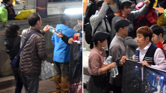 인근 상점에서 나와 생수 수백병을 행진단에게 나눠주고 있다.


