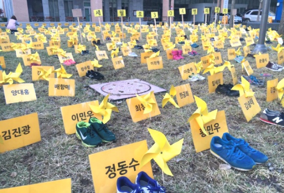 세월호 참사 희생자를 추모하는 뜻에서 학생들이 신발 304개를 마련하여 희생자 이름과 함께 노란 바람개비를 전시하고 있다.  