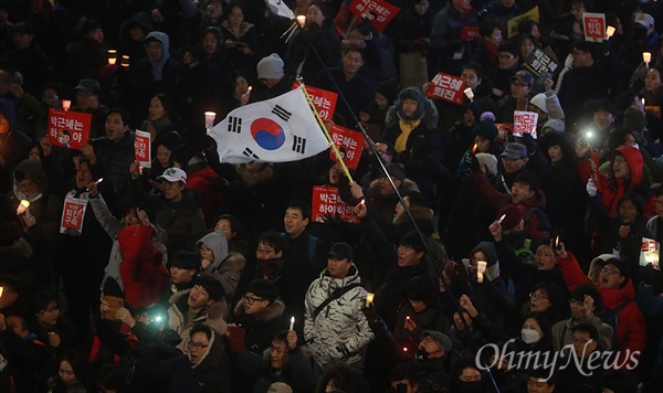 '박근혜 즉각 퇴진 5차 범국민행동'에 참가한 시민이 26일 오후 서울 종로구 통인시장 앞에 모여 태극기를 흔들어보이며 박 대통령의 퇴진을 요구하고 있다.