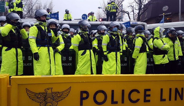 비옷을 입고 방패를 든 경찰들이 청와대 앞 200미터 앞에 차 벽을 세우고 지키고 있다.