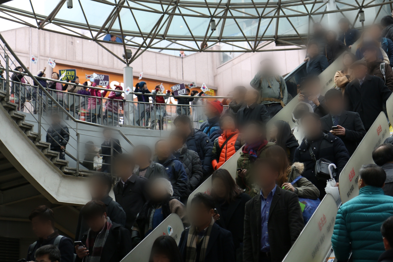 에스컬레이터를 타고 서울역 1번 출구로 내려가는 시민들