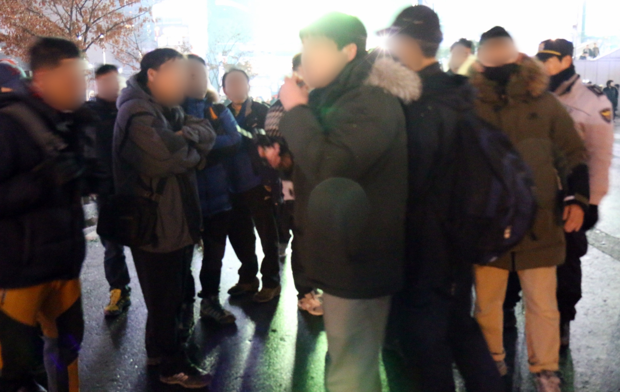 '박근혜 퇴진' 팻말을 들고 서 있던 전훈진(49, 왼쪽 세 번째) 씨를 폭행한 60대 노인(오른쪽 네 번째)이 경찰에게 연행되는 과정에서 시민들과 실랑이를 벌이고 있다