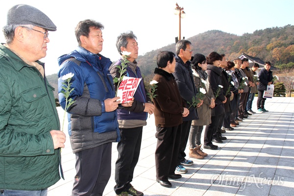 '박근혜퇴진 경남운동본부' 관계자들이 28일 오전 국립3.15민주묘지 기념관을 찾아 박근혜 대통령 사진의 철거를 요청하기에 앞서 국화꽃을 들고 참배부터 했다.