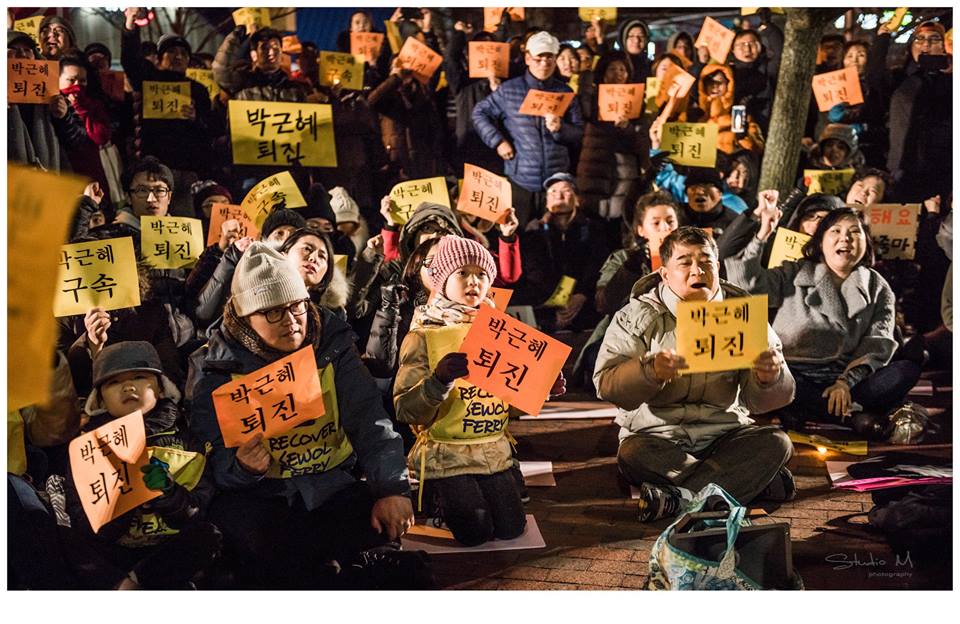뉴욕 집회에 참석한 한 어린이가 세월호 몸자보를 입고 '박근혜 퇴진' 피켓을 들고 있다.