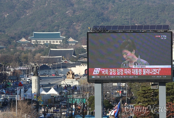 박근혜 3차 대국민담화와 청와대 박근혜 대통령이 29일 오후 최순실 등 비선실세 국정농단 사태에 대한 3차 대국민담화를 발표하고 있다. 언론재단앞 대형스크린에 박 대통령 담화 장면이 생중계되는 가운데, 광화문광장 너머 청와대 본관이 보인다.