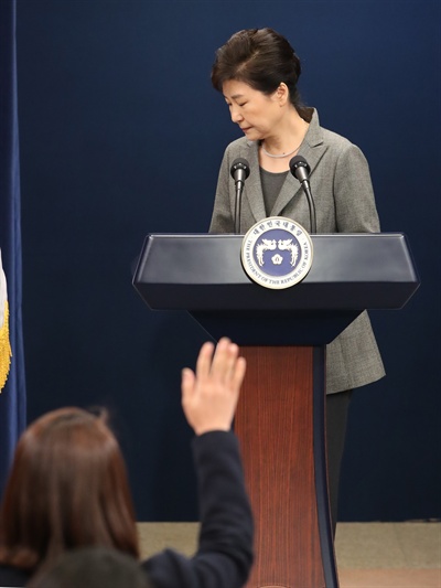 박근혜 대통령이 29일 오후 청와대 춘추관 대브리핑실에서 제3차 대국민담화를 발표한 뒤 돌아서자 한 기자가 손을 들어 질문이 있다고 표시하고 있다.