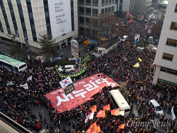 지난 3일 오후 서울 여의도 새누리당사 앞에 모인 시민들이 새누리당 해체를 외치며 새누리당 대형 깃발을 찢고 있다.