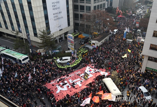 찢어지는 '새누리당' 여의도 새누리당사앞에 모인 시민들이 박근혜 탄핵과 새누리당 해체를 외치며 새누리당을 상징하는 대형 깃발을 찢고 있다.