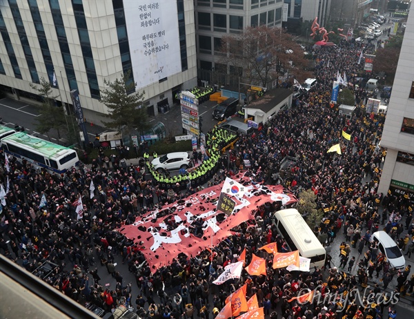 박근혜 대통령 즉각 퇴진과 국회의 탄핵안 가결을 요구하는 6차 촛불집회가 예정된 3일 오후 서울 여의도 새누리당사 앞에 모인 시민들이 새누리당 해체를 외치며 새누리당 대형 깃발을 찢고 있다.