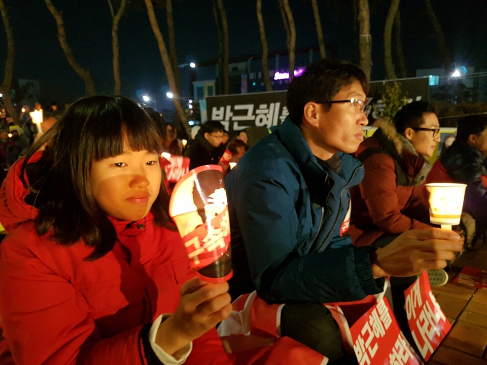 '박근혜퇴진 촉구 서산시민 총궐기 및 행진'에 참가한 초등학생이 아빠와 촛불을 들고있다