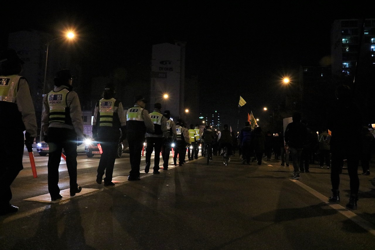경찰들이 집회에 참가한 시민들의 안전을 지키기 위해 도로 중앙선으로 걷고 있다.