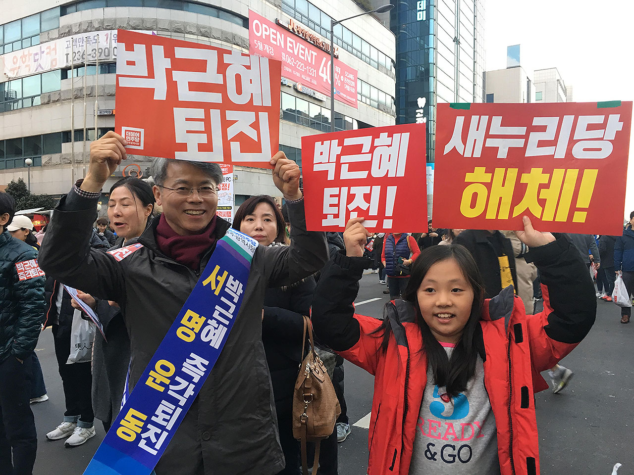 3일 오후 광주 금남로에서 '박근혜 퇴진' 서명운동을 하고 있던 민형배 광주 광산구청장이 아버지와 함께 시국촛불대회에 나온 김연경(초등3) 학생과 손 피켓을 들고 있다.