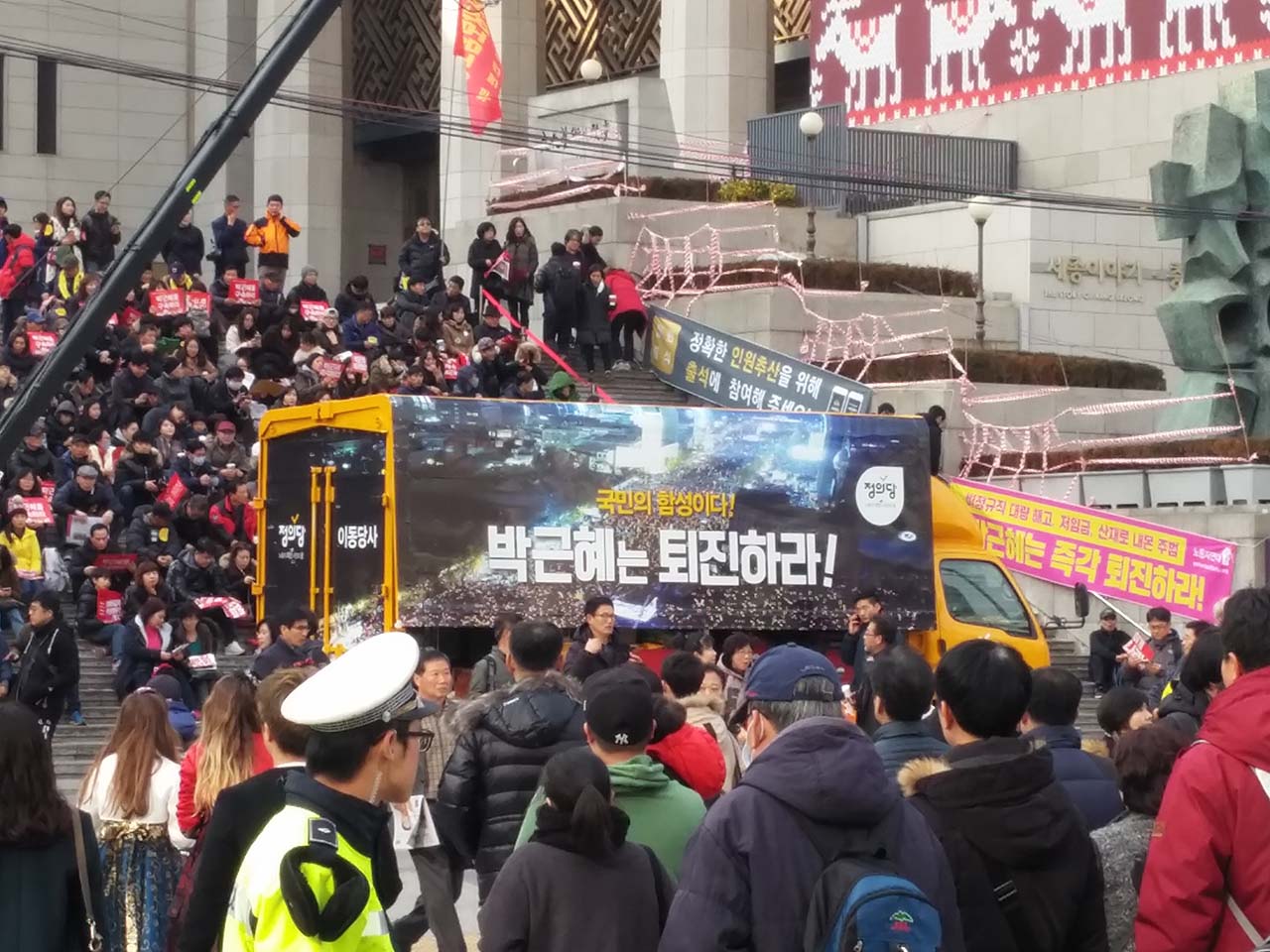 서울 광화문 촛불집회에 참여한 국민들. 세종문화회관 계단에 앉아 있는 국민들.
