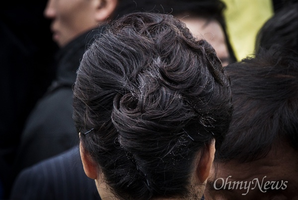 박근혜 대통령이 세월호 참사 1주기인 2015년 4월 16일 진도 팽목항을 방문해 대국민담화를 발표한 후 떠나는 가운데, 머리핀 여러개로 고정한 '박근혜표 올림머리'를 하고 있다.