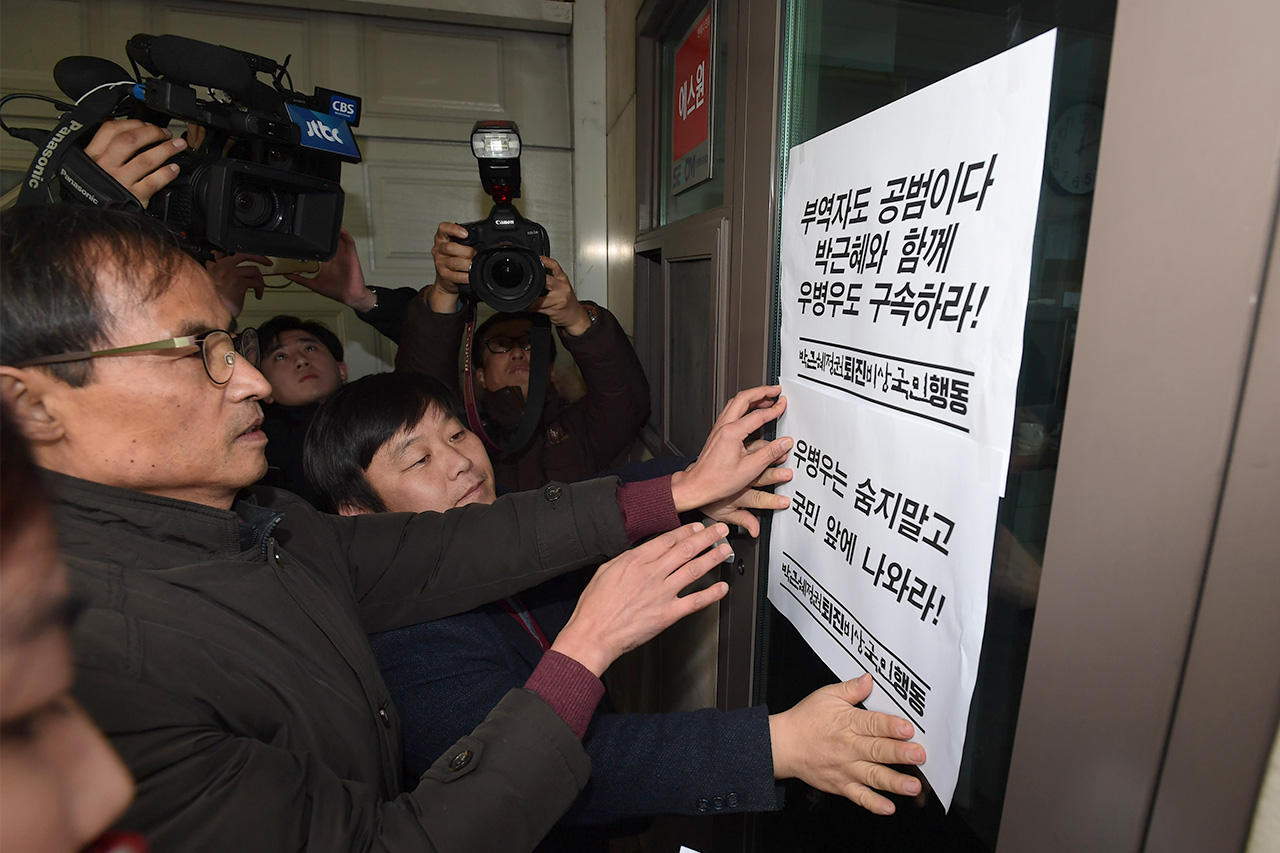  '박근혜 정권 퇴진 비상국민행동' 관계자들이 7일 오후 우병우 전 청와대 민정수석이 은신하고 있는 것으로 알려진 우 수석의 장모 김장자 삼남개발 회장의 자택 보안실 출입구에  청문회 출석을 촉구하는 피켓을 붙이고 있다.
